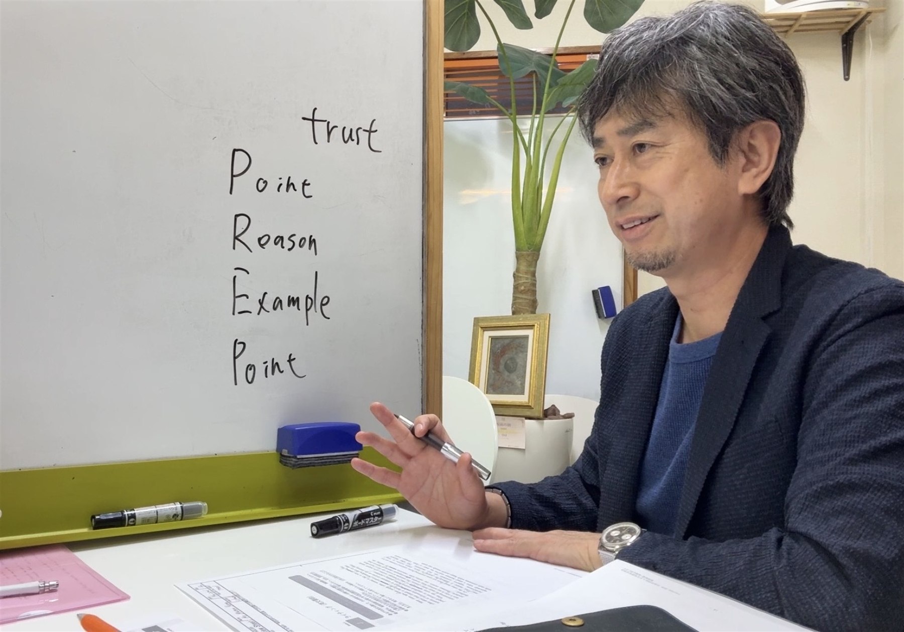 横山元がホワイトボードを使い英作文の考え方を指導している様子